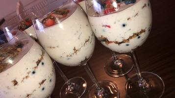 Tres vasos de postre en capas con frutas y granola.