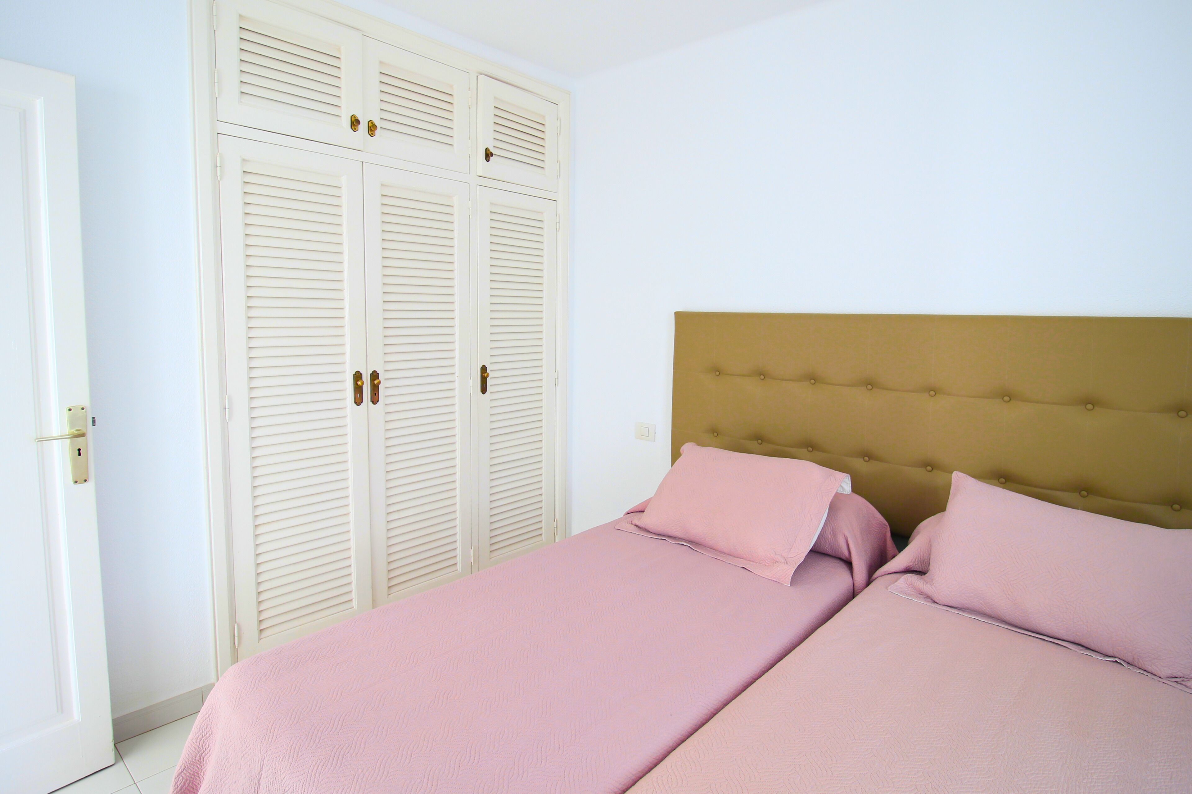 Una camera da letto con un letto, un armadio e una porta.