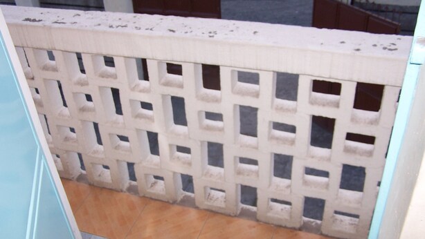 A white, grid-patterned partition with a tiled floor beneath. - Quest Resort (Nakuru)