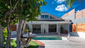 A modern house with a swimming pool, a covered patio, and a wooden deck. - Villa MICELA – Beachfront Escape with Pool in Flamands, St. Barths (Gustavia)