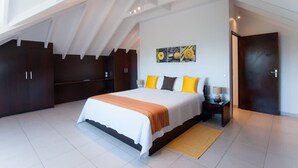 A modern bedroom with a large bed, dark wooden wardrobe, and a skylight. - Villa MICELA – Beachfront Escape with Pool in Flamands, St. Barths (Gustavia)