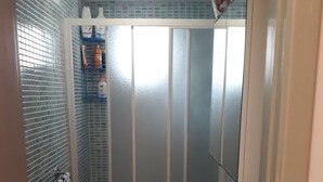 A bathroom with a toilet, a sink, and a shower area. There is a ceiling with a grid pattern and a soccer ball decoration on the wall. - Beautiful house - fiumefreddo (fiumofreddo)