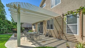 A covered patio with a table and chairs, a pergola, and potted plants. - Family-Friendly Tracy House with Patio & Grill! (Tracy)