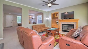 A living room with leather sofas, a coffee table, a fireplace, and a television. - Family-Friendly Tracy House with Patio & Grill! (Tracy)
