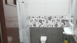 Une petite salle de bain avec des toilettes, un lavabo et un tapis à motifs.