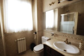 A bathroom with a toilet, sink, and shower.