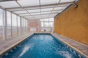 An indoor swimming pool with a glass ceiling, surrounded by walls and a window. - IMPERDIBLE PROMOTION PREMIUM LOFT IN RECOLETA!!! ⭐⭐⭐⭐⭐ (Ciudad Autónoma de Buenos Aires, Recolet)