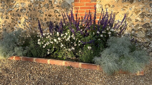 A garden with lavender and white flowers, a stone wall, and a brick structure. - the Grand Potager, a very beautiful calm and preserved environment (Mittainvilliers-Vérigny)