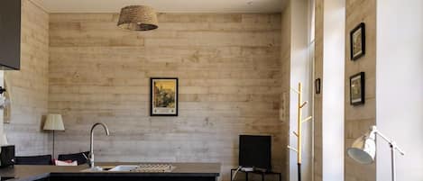 Una cocina moderna con una isla central, muebles oscuros y un ventanal que proporciona luz natural.