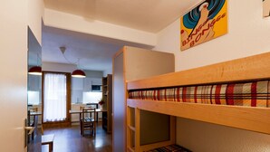 Un dormitorio con literas, un comedor y una cocina.