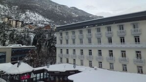 A hotel with multiple floors, balconies, and a mountainous backdrop. - Studio 4 Pers, Center Brides-les-Bains, Wifi, Parking (Brides-les-Bains)