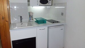 A compact kitchen with white cabinets, a microwave, a coffee maker, and a sink. - Studio 4 Pers, Center Brides-les-Bains, Wifi, Parking (Brides-les-Bains)