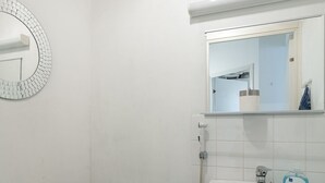 A small, clean bathroom with a toilet, sink, and shower.