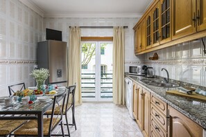 Eine Küche mit Essbereich, ausgestattet mit Kühlschrank, Mikrowelle, Spüle und Holzschränken.