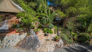 A garden with stone steps, various plants, and a lamp post. - Cubo's Jacaranda Rural Cottage / Private Pool / Views (Guaro)