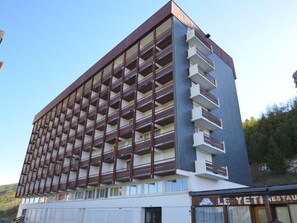 A multi-story building with a modern architectural design, featuring a series of balconies on each floor.