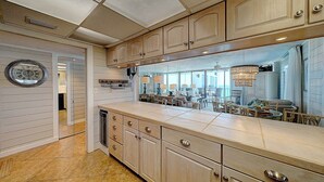 Una cocina con armarios de madera, una isla grande y vista al área de comedor.