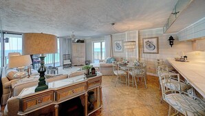 Amplia sala de estar con una mesa de comedor, sillas y un sofá.