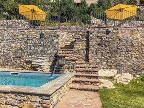 Una piscina al aire libre, sillones reclinables de piscina