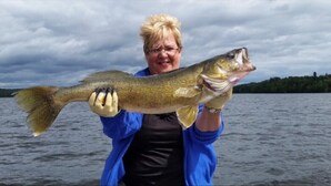 A person holding a fish. - Rustic Canadian Fishing Experience (Dryden)