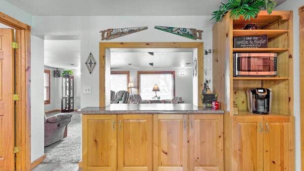 A kitchen with wooden cabinets, a microwave, and a coffee maker on the countertop. - Family Home w/ Hot Tub - Walk to Johnson Lake! (Johnson Lake)