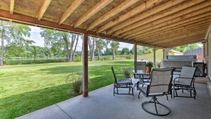 An outdoor patio with a covered area, concrete flooring, and metal chairs. - Family Home w/ Hot Tub - Walk to Johnson Lake! (Johnson Lake)