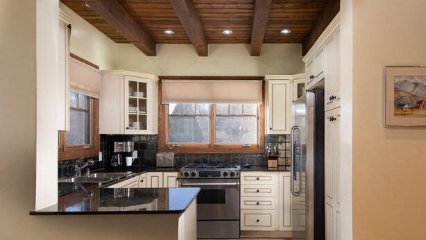 A kitchen with a central island, built-in appliances, and a window with blinds. - Short stroll to the historic plaza, Canyon Road & Railyard District Restaurants (Santa Fe)