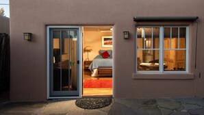 A single-story building with a sliding glass door leading to a bedroom. - Short stroll to the historic plaza, Canyon Road & Railyard District Restaurants (Santa Fe)