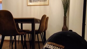 A dining area with a wooden table and chairs, a ceiling light fixture, and a framed picture on the wall. - Bright and Cozy Two-room apartment with balcony overlooking the Matterhorn (Breuil-Cervinia)