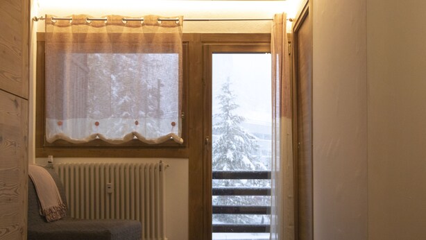 A room with a window, a radiator, and a view of a snowy landscape. - Bright and Cozy Two-room apartment with balcony overlooking the Matterhorn (Breuil-Cervinia)