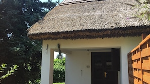 A building with a thatched roof and a wooden fence. - The Cottage with a big private garden (Keszthely)
