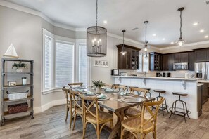 A modern kitchen with a central island, dark cabinetry, and pendant lighting.