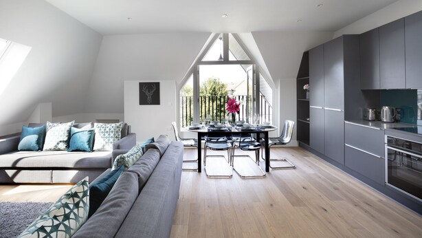 En moderne loftlejlighed med spiseplads, køkken og opholdsstue.
