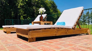 Una piscina al aire libre de temporada, sillones reclinables de piscina
