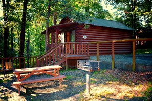 A rustic cabin with a wooden deck and a picnic table. - Cozy Cabin with Fire Pit pavilion near boat ramp (Broken Bow)