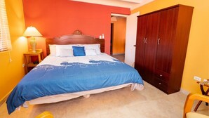 Une chambre à coucher avec un lit, une table de chevet, une lampe et une armoire.