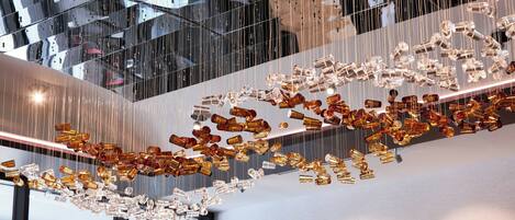 A modern interior with reflective surfaces and hanging elements.