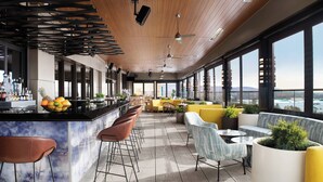 A modern bar area with a counter, stools, and seating. - AC Hotel Bridgewater (Bridgewater)