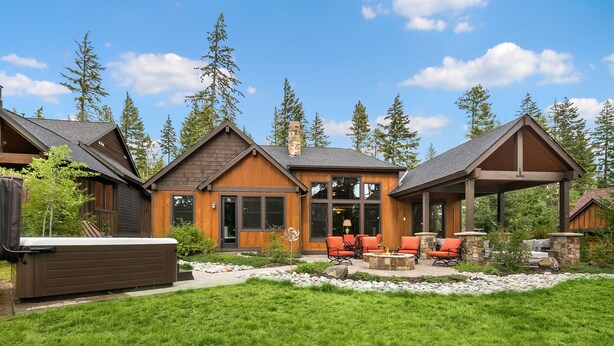 A modern house with a patio, outdoor seating, and a hot tub.