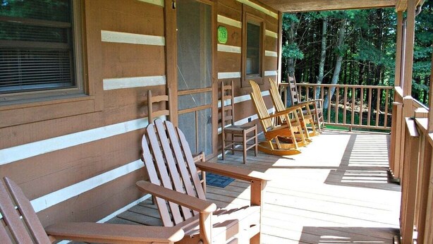 A wooden cabin with a porch, wooden chairs, and a sign welcoming visitors to the mountains. - Sweet Retreat-NC cabin with mountain & river views, firepit, Smart TV, River Tubes, (Jefferson)