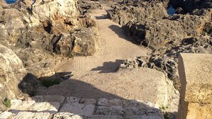 A rocky coastal area with a clear view of the sea.