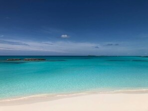 Una playa con agua turquesa cristalina y una orilla de arena blanca.