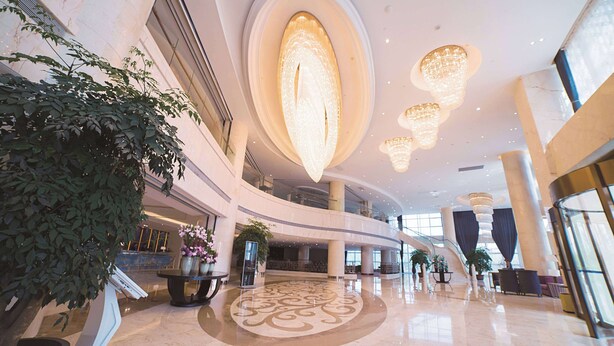 A spacious lobby with a high ceiling, large chandeliers, and a central decorative light fixture. - Days Hotel & Suites by Wyndham Jiangsu Xinyi (Xuzhou)