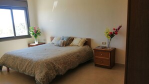 Une chambre à coucher avec un lit, deux tables de chevet et une fenêtre.