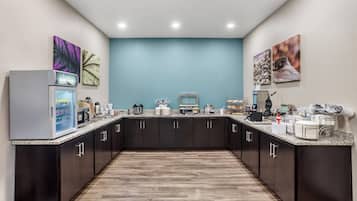 A modern kitchen with dark cabinets, a granite countertop, and various appliances.