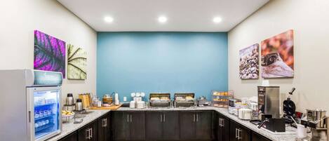 Una cocina moderna con una isla central, equipada con diversos electrodomésticos y un refrigerador.