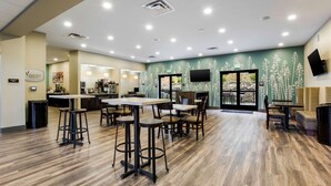A modern restaurant with a wooden floor, bar area, and seating. - Sleep Inn Winfield - Teays Valley (Hurricane)