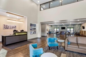 A hotel lobby with a reception desk, seating area, and a dining space. - Sleep Inn Winfield - Teays Valley (Hurricane)