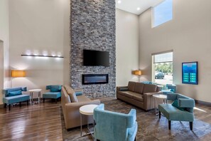 A spacious lobby with a stone accent wall, a flat-screen TV, and comfortable seating areas. - Sleep Inn Winfield - Teays Valley (Hurricane)