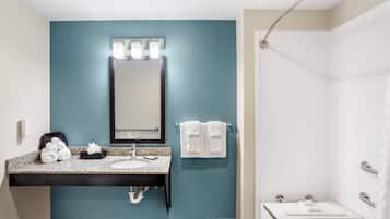 A bathroom with a sink, mirror, towel rack, and shower.